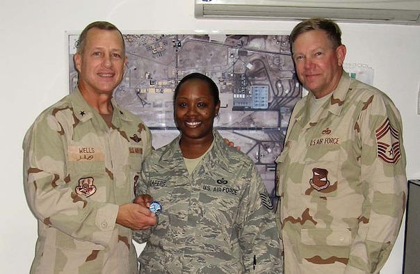Brig. Gen. Lawrence Wells, 380th Air Expeditionary Wing Commander, and Chief Master Sgt. Joseph Newhart, congratulate Tech. Sgt. Chante Capers, 380th Air Expeditionary Wing Command Post, on her selection as the Air Force Level Command Post Noncommissioned Officer of the Year for 2007. One team, one fight! (Courtesy Photo)