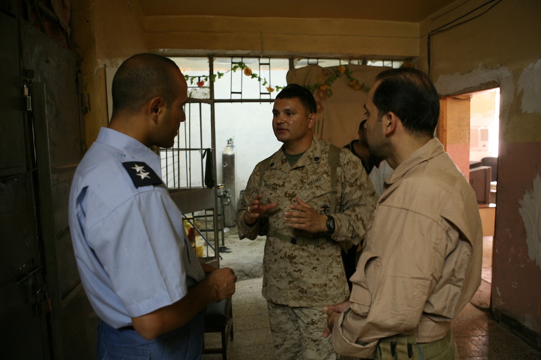 Staff Sgt. Luis C. Cardenas, detainee operations staff, Company B, Iraqi Transition Team 8, Regimental Combat Team 1, speaks with a detainee officer at Fallujah Major Crimes Prison in Fallujah, Iraq, June 7. Cardenas, who is from Kingwood, Texas, works with young juvenilles on a daily basis at the prison. (Official Marine Corps photo by Cpl. Chris T. Mann)