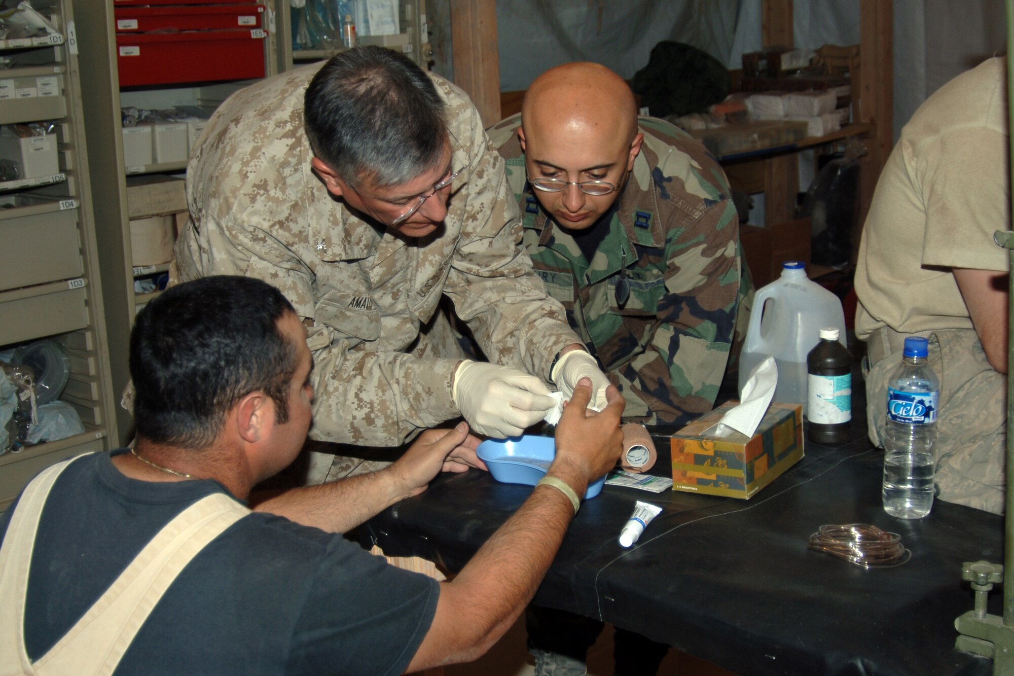 U.S. Navy Dr.(Capt.) Peter Amato (left), deployed from Westover Air Force Base, Mass., and Air Force Dr. (Capt). Ronald Khoury, deployed from Nellis AFB, Nev., assist a patient with a severe cut wound, June 6.  The doctors are in the mountainous region of Ayacucho, Peru participating in New Horizons - Peru 2008, a U.S. Southern Command- sponsored humanitarian mission set on improving the quality of life of underprivileged Peruvians. 