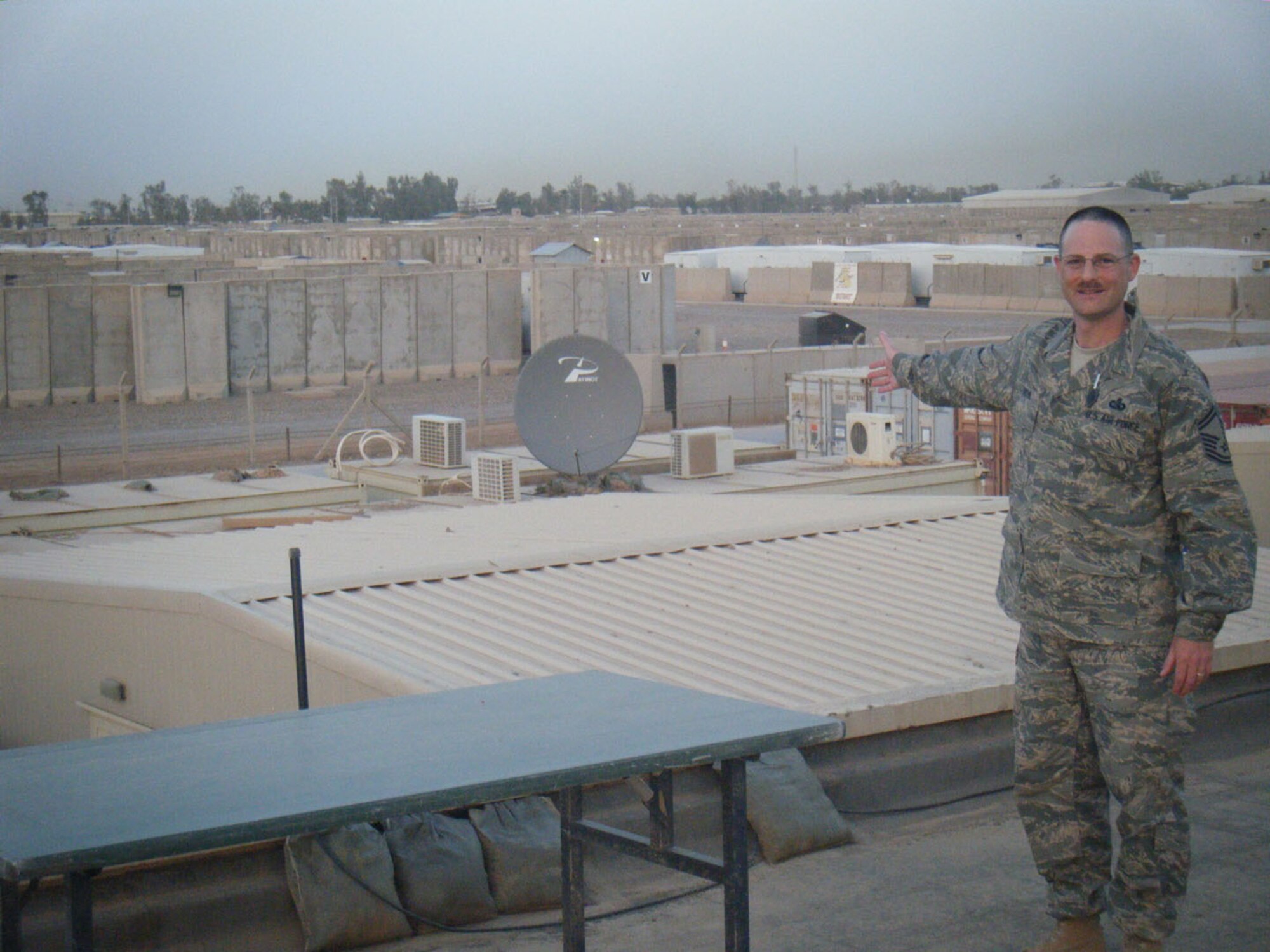 SEYMOUR JOHNSON AIR FORCE BASE, N.C. -- Senior Master Sgt. Bryan Payne, a Reservist with the 916th Communications Squadron, points to housing at the start of a clear day in Iraq. In the second picture you can see what a difference a few hours can make in Iraqi visibility.