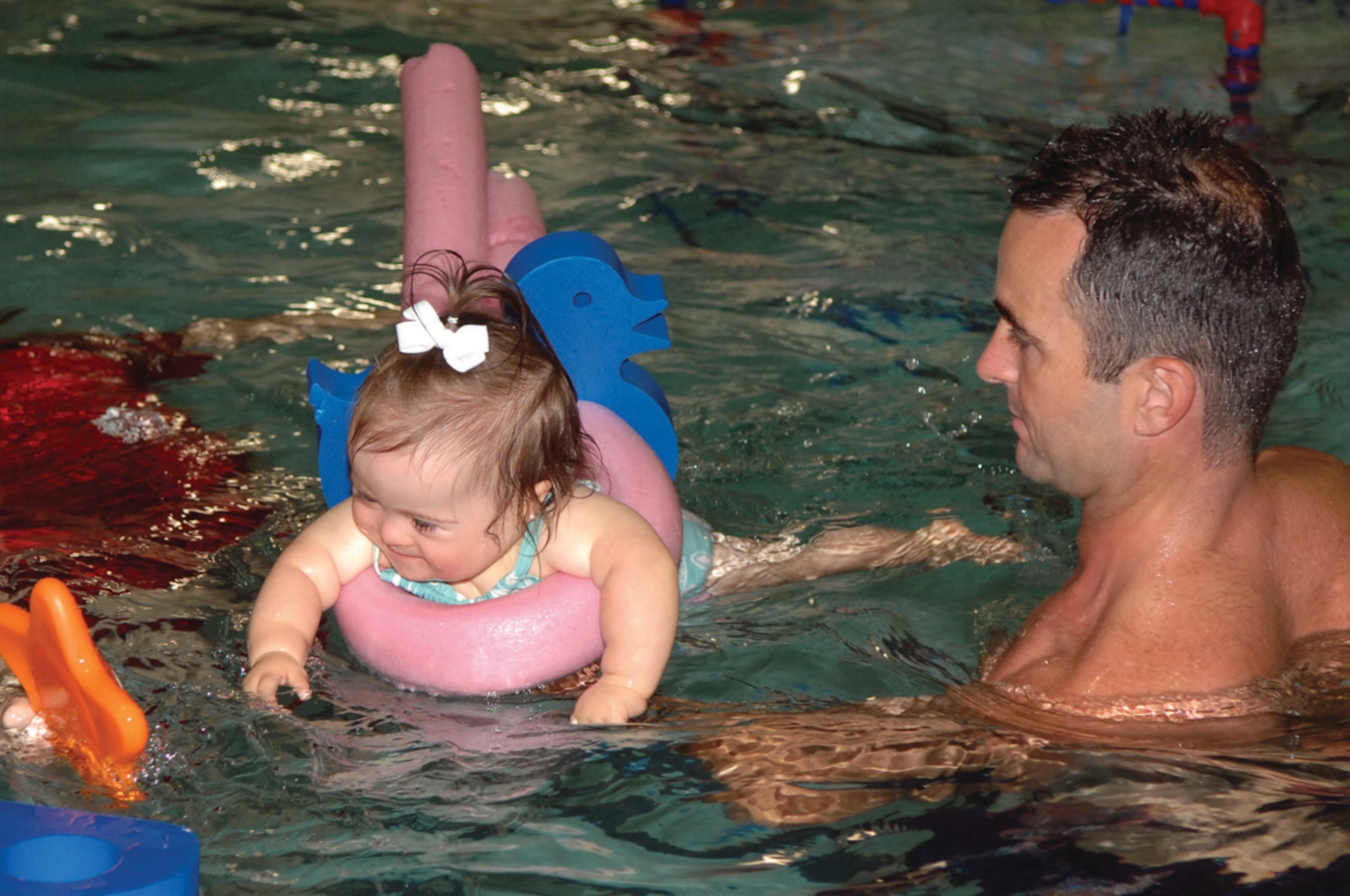 Heath White, member of the 93d Bomb Squadron, helps his youngest daughter, Paisley, learn how to swim Thursday, May 5, at a local swim school in Shreveport, La. (U.S. Air Force photo/Airman 1st Class Joanna Kresge)