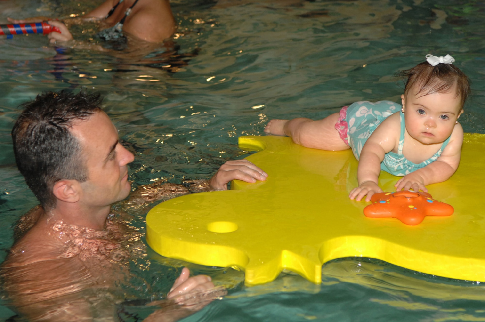 Heath White, member of the 93d Bomb Squadron, helps his youngest daughter, Paisley, learn how to swim Thursday, May 5, at a local swim school in Shreveport, La. (U.S. Air Force photo/Airman 1st Class Joanna Kresge)