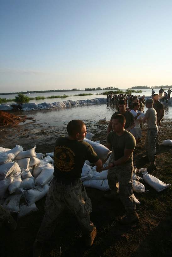Local residents of Elnora, Ind., Marines and sailors of 26th Marine Expeditionary Unit and soldiers from Indiana National Guard stack sand bags to reinforce the levees from flooding of the White River June 9, 2008, in Elnora, Ind.  Local authorities in Elnora requested the 26th MEU to provide support to reinforce the levees from flooding of the White River. (Official USMC photo by Lance Cpl. Patrick M. Johnson-Campbell.) (Released)