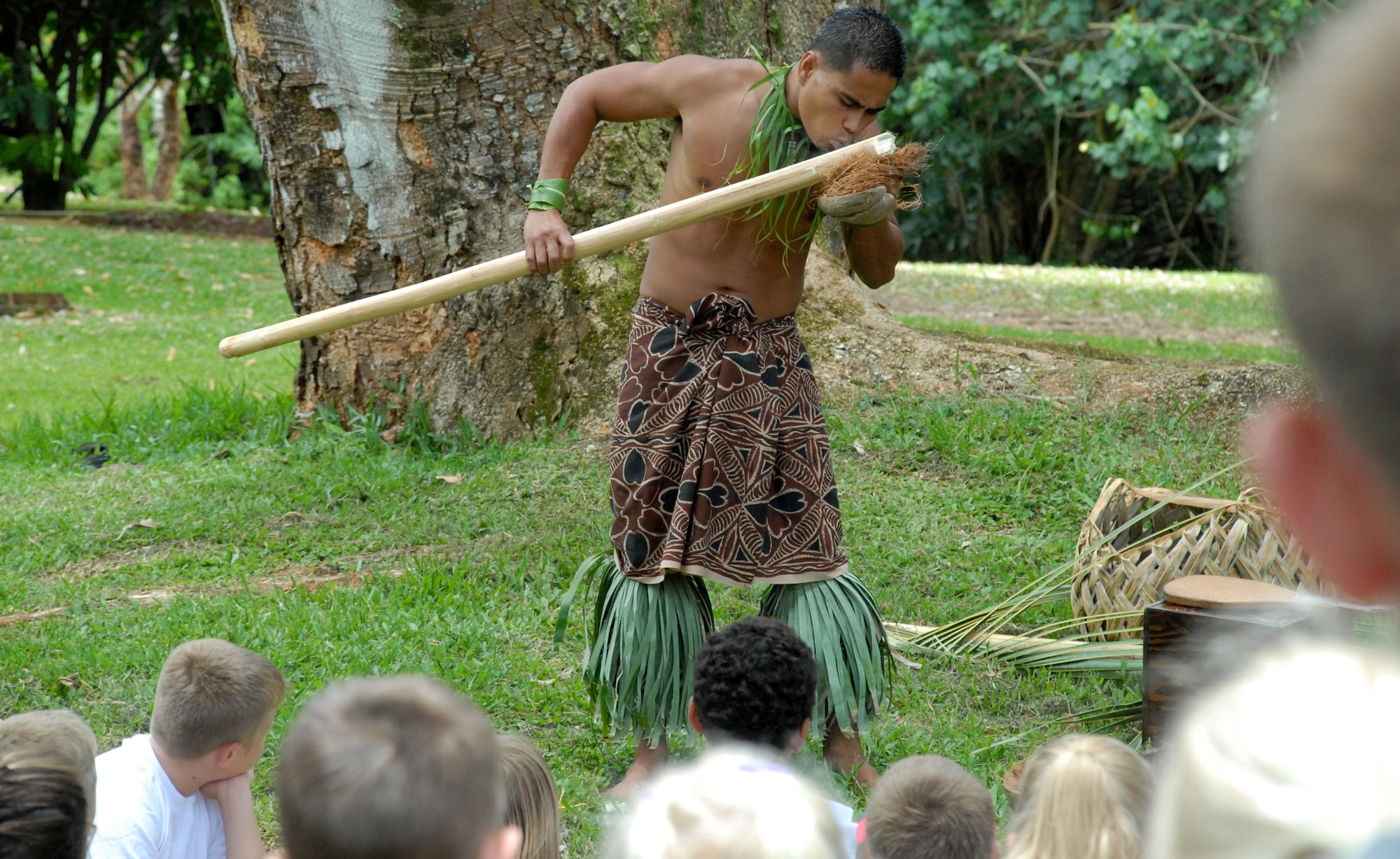 Chris Lifu, Polynesian Cultural Center, shows children how to b uild a fire and open a coconut, during a demonstration at the beginning of the 9th Annual Keiki Fishing Tournament, June 6, at Ho'omaluhia Botanical Gardens, Kaneohe, Hi. (U.S. Air Force photo/Staff Sgt. Erin Smith)