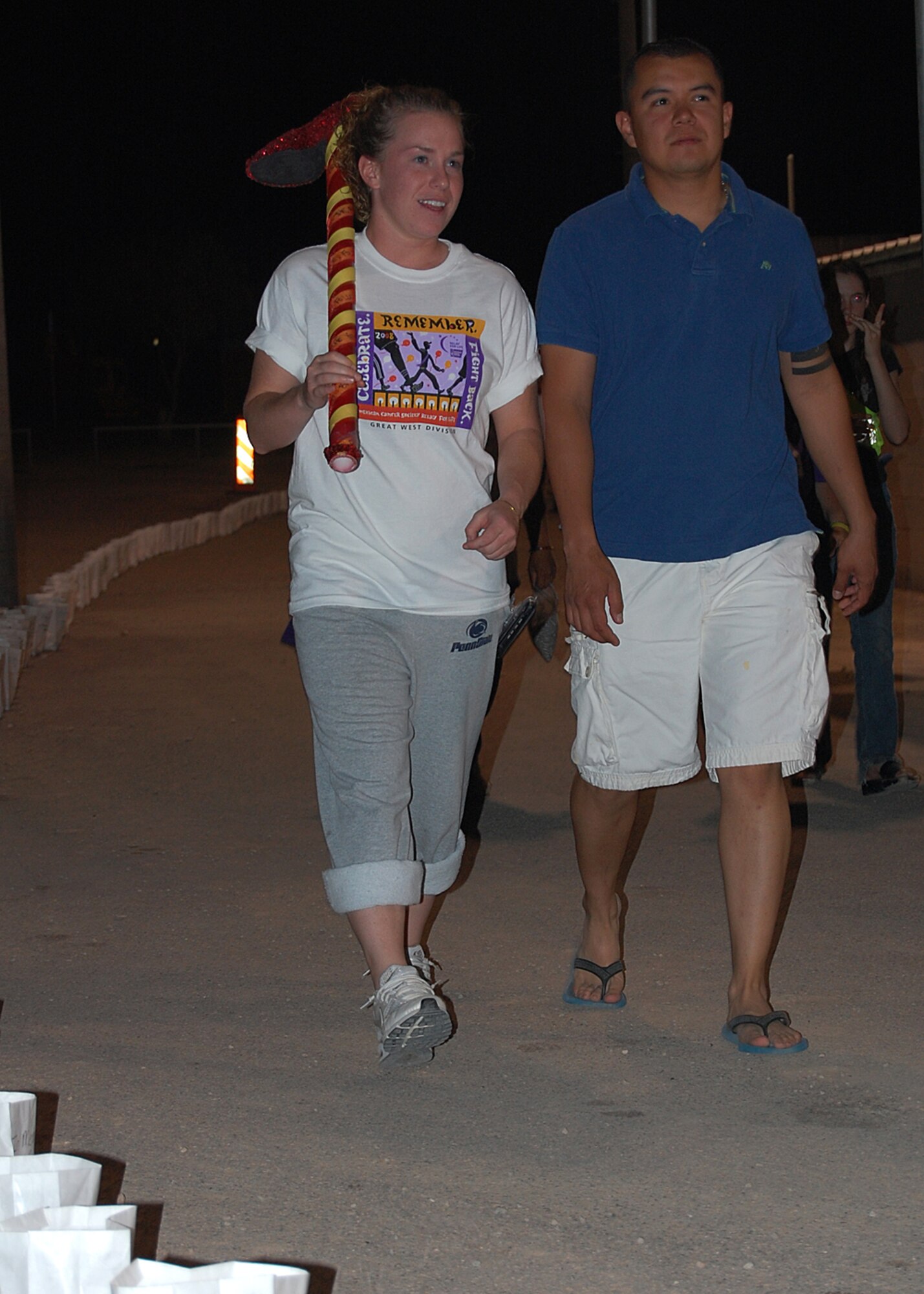 Airman 1st Class Krista Lawrence and Airman 1st Class Alvaro Vega, 49th Civil Engineer Squadron, walk around the track during Relay For Life in honor of people who are battling cancer or have died of cancer. Members of Team Holloman and residents from Alamogordo paticipated in Relay For Life to pay tribute to the lives lost to the disease, and raise money to help fight it. Teams of eight to 15 members gathered with tents and sleeping bags with the goal of keeping one person on the track at all times. (U.S. Air Force photo/Airman 1st Class Michael Means)