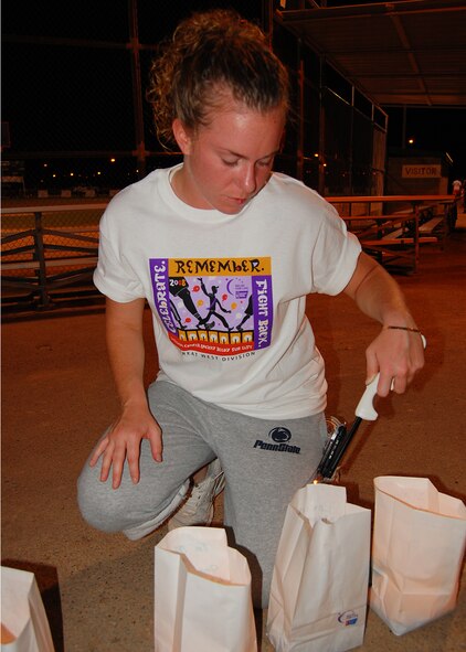 Airman 1st Class Krista Lawrence, 49th Civil Engineer Squadron, lights luminaries in honor of people who are battling cancer or have died of cancer during Relay For Life in Alamogordo, N.M., the evening of June 7. Members of Team Holloman and residents from Alamogordo paticipated in Relay For Life to pay tribute to the lives lost to the disease, and raise money to help fight it. Millions of lives have been saved as a result of the Society's major discoveries in cancer research. (U.S. Air Force photo/Airman 1st Class Michael Means)