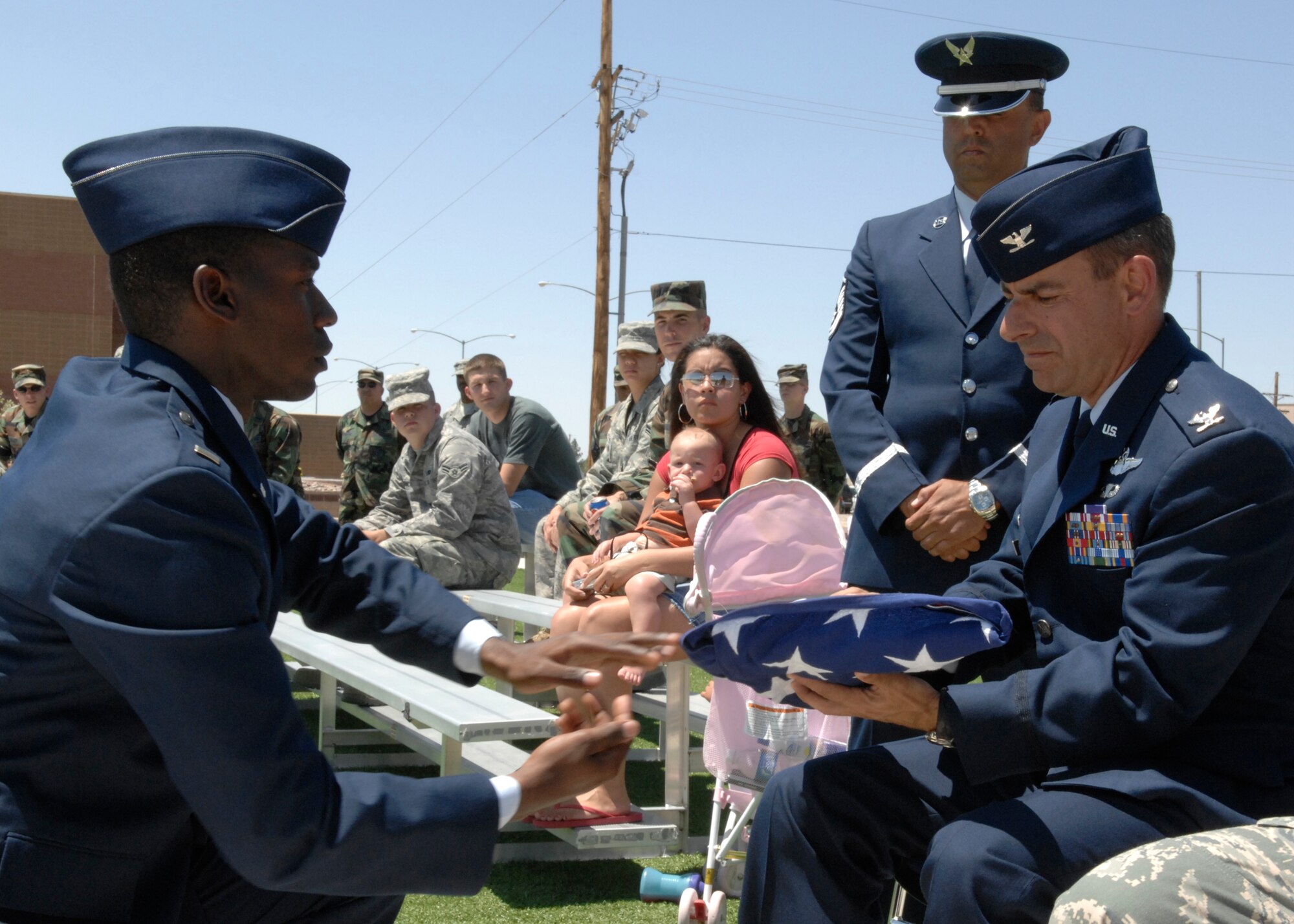 A new member of the Steel Talons Honor Guard presents the American Flag to Col. Jeff Harrigian, 49th Fighter Wing commander, during their graduation ceremony, June 3 at Heritage Park on Holloman Air Force Base,N.M. The Honor Guard averages 20-30 ceremonies per month. (U.S. Air Force photo/Airman 1st Class Rachel A. Kocin)