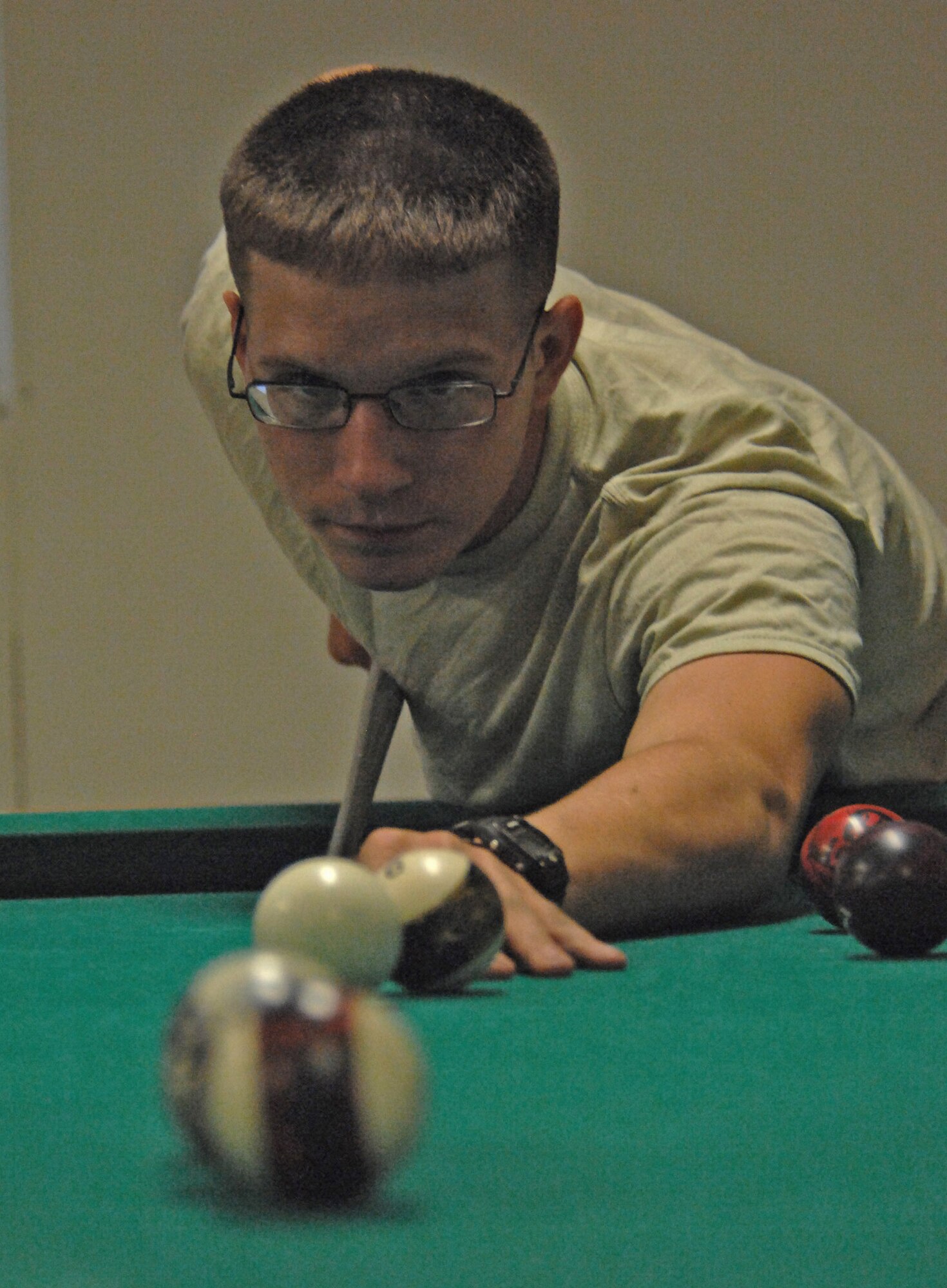 Army Pvt. Tyler Rogers focuses on making a shot on a pool table May 28 at the morale, welfare and recreation facility at a base in the Laghman Province in Afghanistan. Private Rogers is a mechanic for 4th Battalion, 319th Airborne Field Artillery Regiment deployed from Bamberg, Germany. (U.S. Air Force photo/Master Sgt. James Law) 
