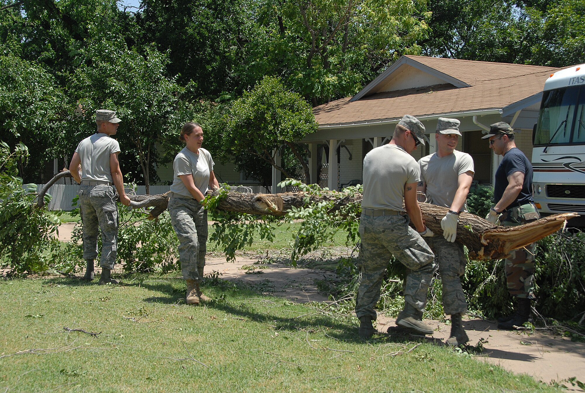 Altus Air Force Base Airmen volunteers help an Altus, Okla. resident in the aftermath of a storm that struck the evening of June 5, 2008. Winds gusting to 87 mph felled trees, damaged electrical grids and damaged more than 100 residences. The Airmen assisted in clean up on Altus AFB and then were released to help area residents clear debris. (U.S. Air Force/A1C Cherice Bryant)
