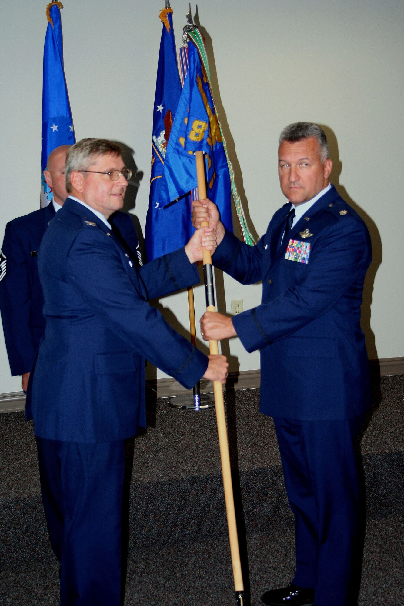 WRIGHT-PATTERSON AFB, Ohio - Col. Roger Gallet (left), 445th Operations Group commander, passes the guidon to incoming 89th Airlift Squadron Commander Lt. Col. Mike Bending during the change of command ceremony June 7, 2008.  The 89th Airlift Squadron is a flying squadron within the 445th Airlift Wing.  (U.S. Air Force photo/Staff Sgt. Martin Moleski)