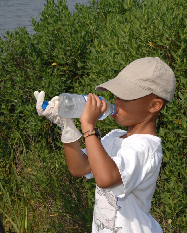 LANGLEY AIR FORCE BASE, Va. -- Isaiah McLaughlin son of Staff Sgt. Danielle McLaughlin, Headquarters Air Combat Command, conference center technician, stops to take a drink or water during Langley’s 20th annual Clean the Bay Day June 7.  Sergeant McLaughlin and her son were part of 187 volunteers that collected1.25 tons of trash. (U.S. Air Force photo/Tech. Sgt. April Wickes)