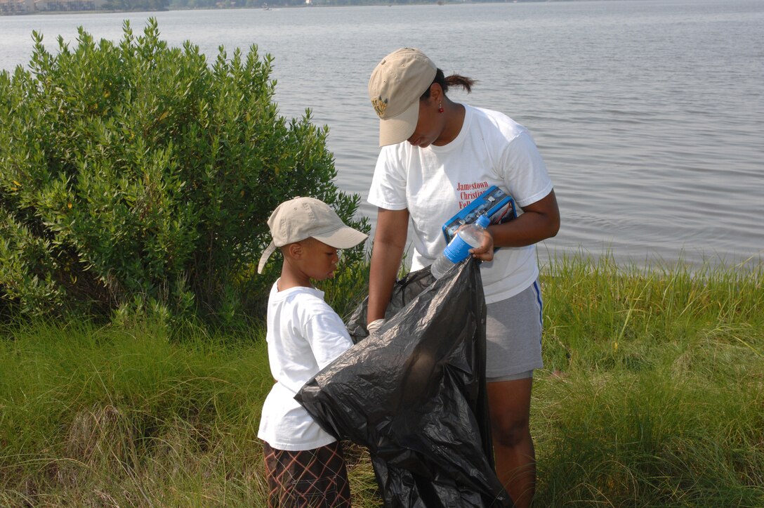 LANGLEY AIR FORCE BASE, Va. -- Isaiah McLaughlin and his mother Staff Sgt. Danielle McLaughlin, Headquarters Air Combat Command, conference center technician, work together to pick up trash during Langley’s 20th annual Clean the Bay Day June 7.  Sergeant McLaughlin and her son were part of 187 volunteers that collected1.25 tons of trash. (U.S. Air Force photo/ Tech. Sgt. April Wickes)