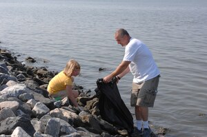 LANGLEY AIR FORCE BASE, Va. -- Isabelle Ebert and her father, Chief Master Sgt. Don Ebert, 1st Aerospace Medicine Squadron flight chief, work together to pick up trash during Langley’s 20th annual Clean the Bay Day June 7.  Chief Ebert and his daughter were part of 187 volunteers that collected 1.25 tons of trash. (U.S. Air Force photo/Tech. Sgt. April Wickes)