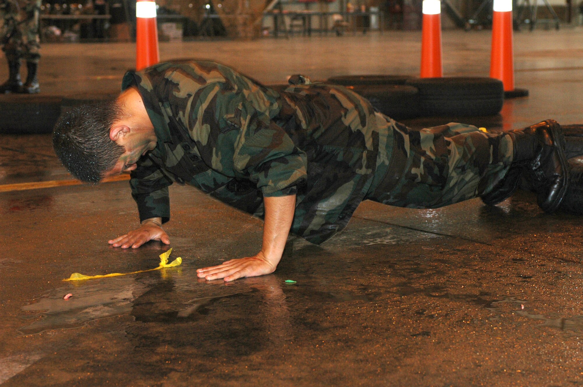 After shuffling his way through a tire obstacle, a member of Team Travis has to complete 10 pushups before moving on in the obstacle course. Dining-in participants who broke the rules of engagement were forced to finish the course while being attacked by the rest of the mess armed with water guns and balloons. (U.S. Air Force photo/Senior Airman Shaun Emery)