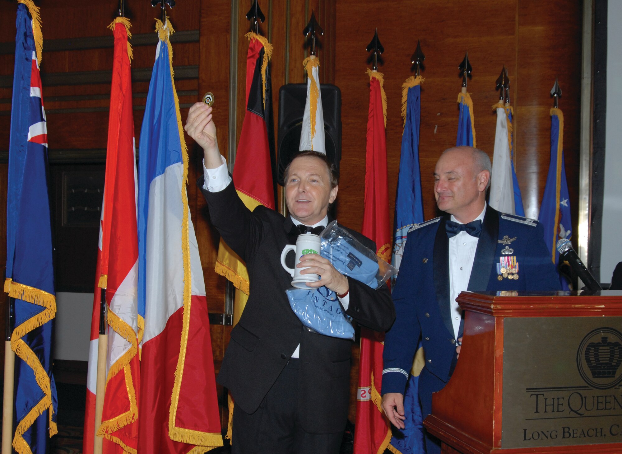 Col Dave Madden, commander, GPSW, presents wing coin, GPS shirt and stein to Fred Travalena, Hollywood entertainer and impersonator at the GPS Dining Out. (photo by Joe Juarez)