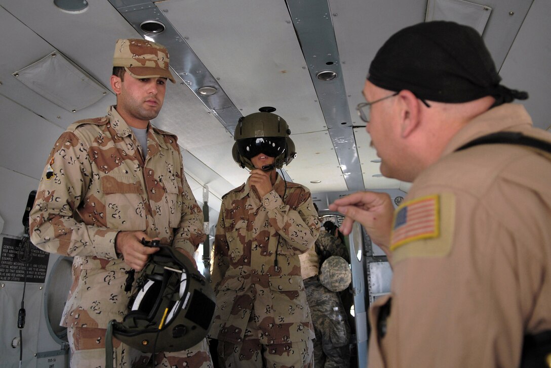 Master Sgt. Bradley Martens gives last-minute instructions to Iraqi air force aerial gunner trainees before a mission May 29 over Camp Taji, Iraq. Sergeant Martens is the 770th Air Expeditionary Advisory Squadron lead aerial gunner training instructor deployed from Hurlburt Field, Fla. (U.S. Air Force photo/Senior Airman Julianne Showalter) 