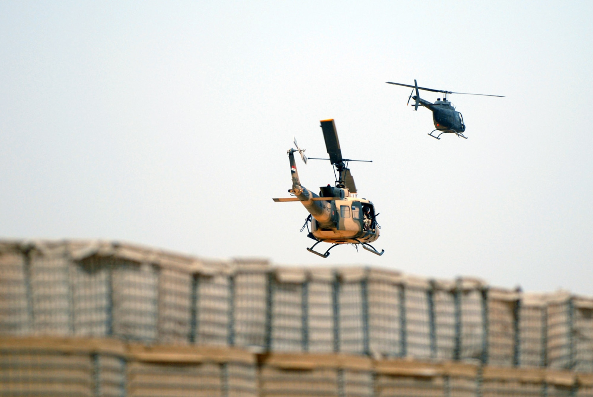 An Iraqi air force UH-1 Huey II and a U.S. Army OH-58 Kiowa fly in formation during an aerial gunner and helicopter training mission May 28 over Camp Taji, Iraq. American Airmen assigned to the 770th Air Expeditionary Advisory Squadron teach the Iraqi aerial gunners and pilots how to carry out their missions in the sky to become a self sustaining force in their country. (U.S. Air Force photo/Senior Airman Julianne Showalter) 
