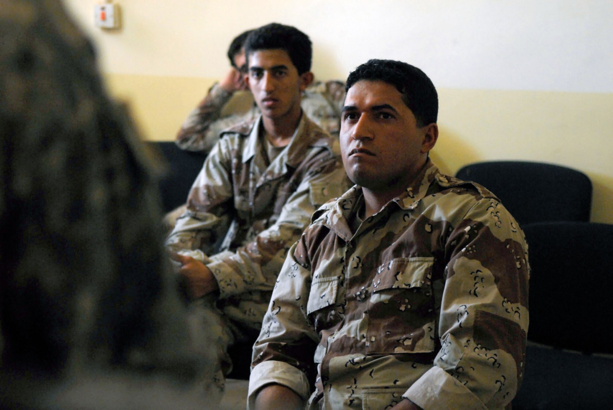 Iraqi air force aerial gunner trainees listen in as an interpreter relays the message of the instructor May 29 at Camp Taji, Iraq. With the assistance of a translator and hand gestures, this obstacle is overcome to ensure the correct message is relayed and understood by the trainees. (U.S. Air Force photo/Senior Airman Julianne Showalter) 
