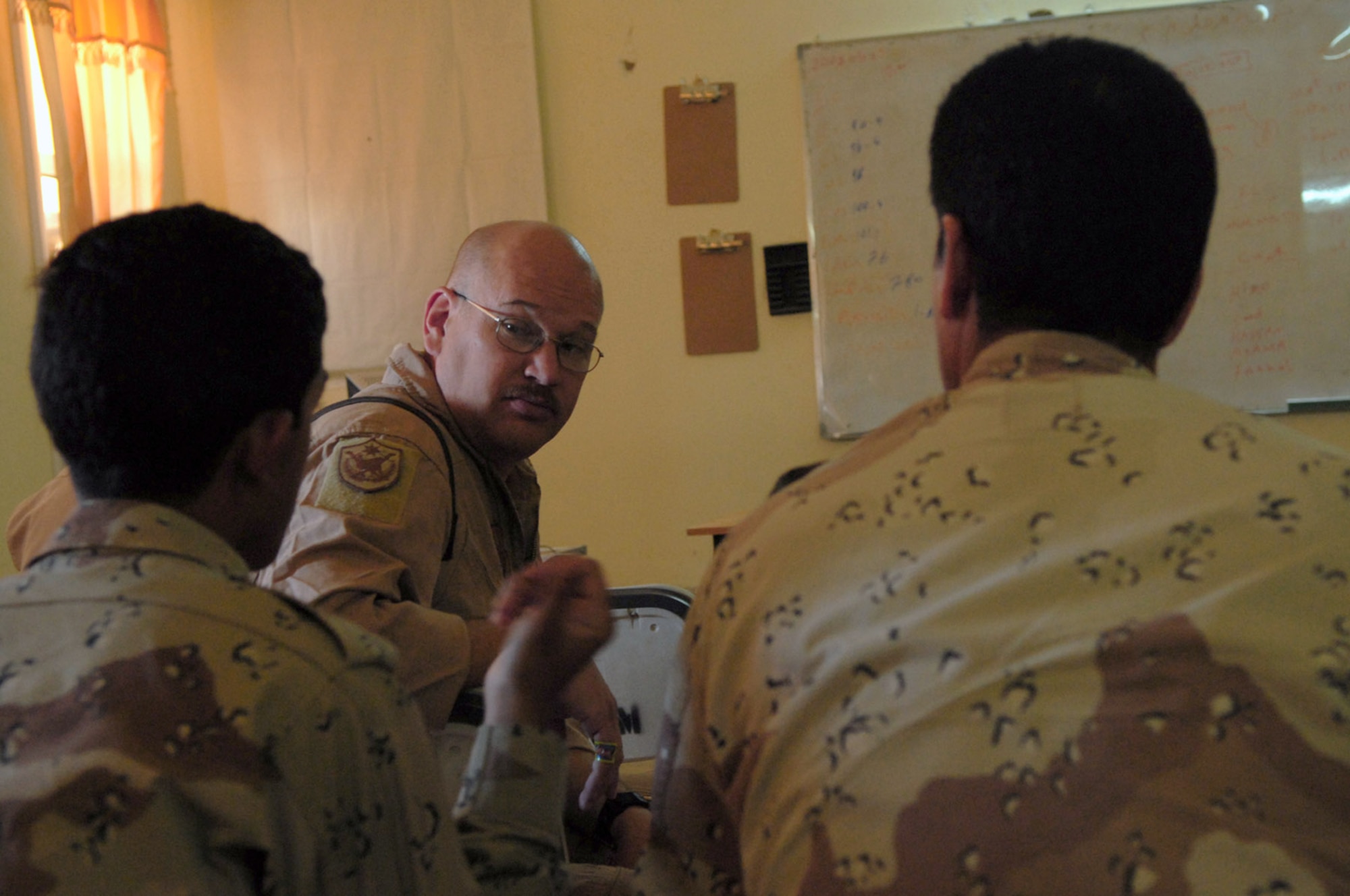 Master Sgt. Bradley Martens speaks with Iraqi air force trainees about procedures before a mission May 29 at Camp Taji, Iraq. Sergeant Martens is the 770th Air Expeditionary Advisory Squadron lead aerial gunner training instructor deployed from Hurlburt Field, Fla. (U.S. Air Force photo/Senior Airman Julianne Showalter) 

