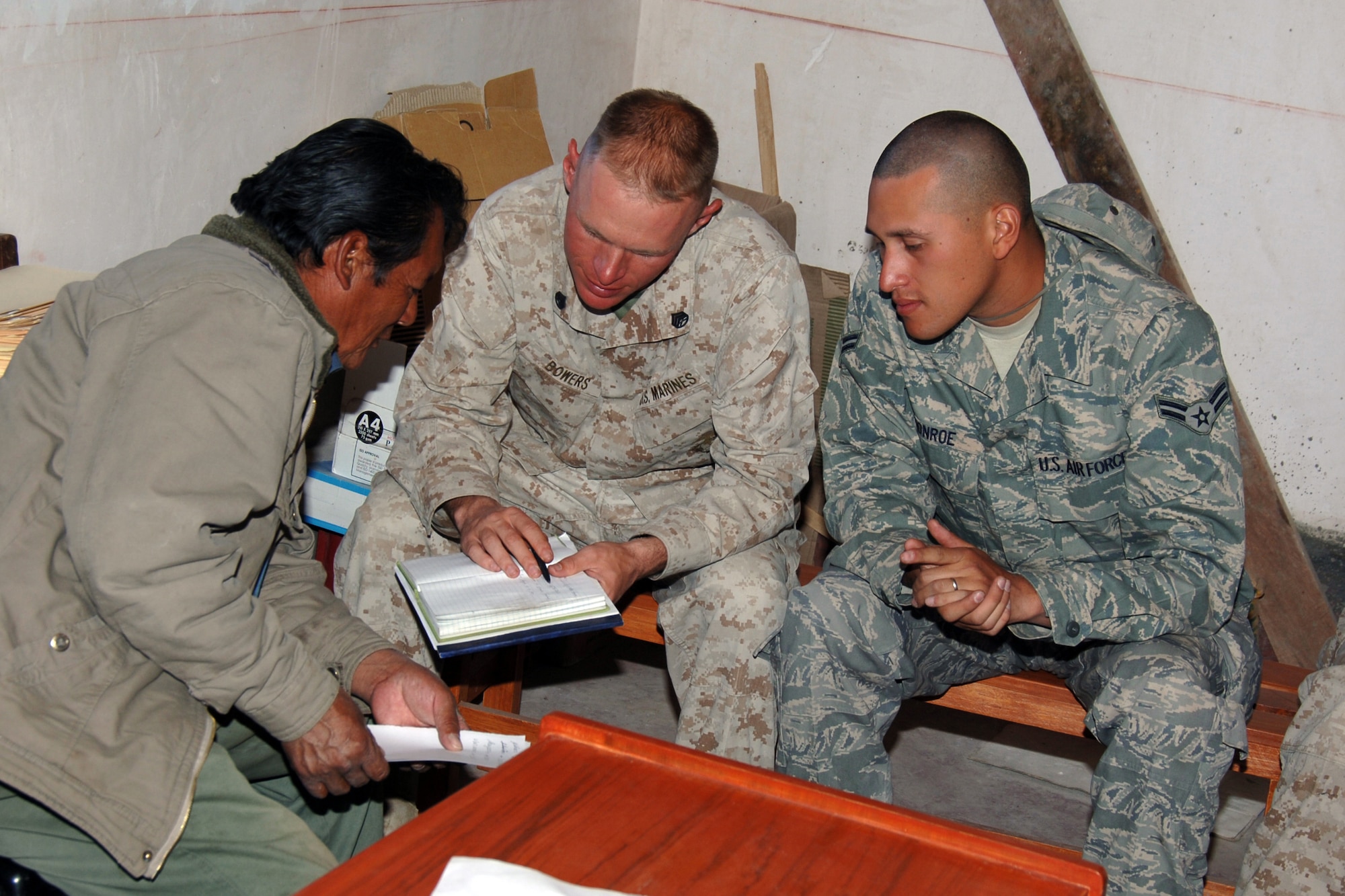 U.S. Marine Staff Sgt. Todd Bowers (left), a civil affairs specialist assigned to the Anacostia Naval Annex, Washington D.C., and U.S. Air Force Airman 1st Class George Monroe, assigned to Tinker Air Force Base, Okla., discuss the local community with Julio, the President of Yanama, Peru. U.S. servicemembers are in Peru supporting New Horizons –Peru 2008, a U.S. Southern Command-sponsored humanitarian mission set on improving the lives of underprivileged Peruvians.  
