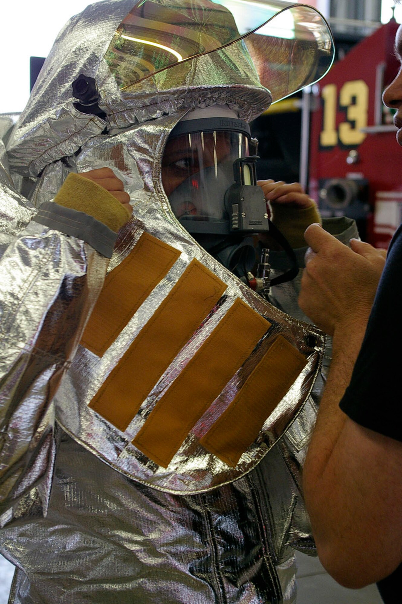 Master Sgt. Gary Peot, right, 100th CES Fire Department, checks the fit of a face mask on Karen Abeyasekere, 100th ARW Public Affairs, when she and two other 100th ARW members got to participate in live fire training with the fire department June 4. The RAF Mildenhall firefighters were training a group of civilian firefighters from Lajes-Field fire department, and the three 100th ARW members were given the opportunity to train with them. (U.S. Air Force photo by Senior Airman Teresa Hawkins)