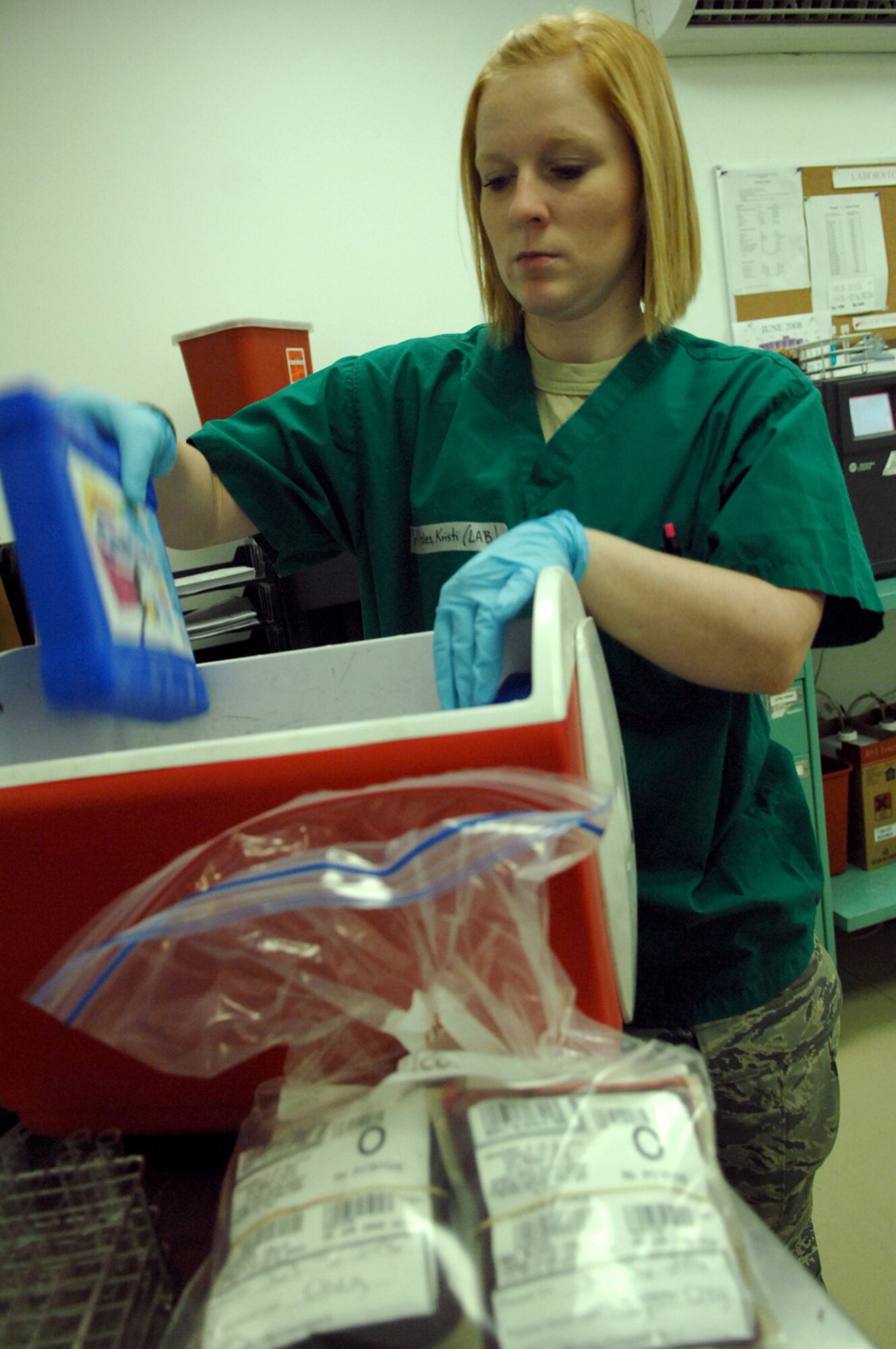 BALAD AIR BASE, Iraq -- Senior Airman Kristi Hales, 332nd Expeditionary Medical Support Squadron lab technician, places ice packs into a cooler for a grab-and-go kit used to respond to emergency patient situations at the Air Force Theater Hospital here, June 5. Airman Hales is deployed from Lackland Air Force Base, Texas. (U.S. Air Force photo/ Senior Airman Julianne Showalter)