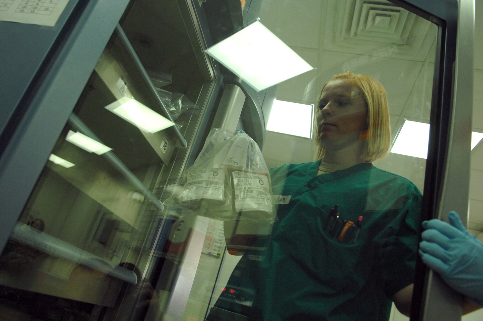 BALAD AIR BASE, Iraq -- Senior Airman Kristi Hales, 332nd Expeditionary Medical Support Squadron lab technician, pulls blood products out of a refrigerator to be used for a patient in the emergency room at the Air Force Theater Hospital here, June 5. Lab technicians are on constant alert for emergency situations and have kits prepared for any potential casualties arriving in the emergency room or operating room. Airman Hales is deployed from Lackland Air Force Base, Texas. (U.S. Air Force photo/ Senior Airman Julianne Showalter)