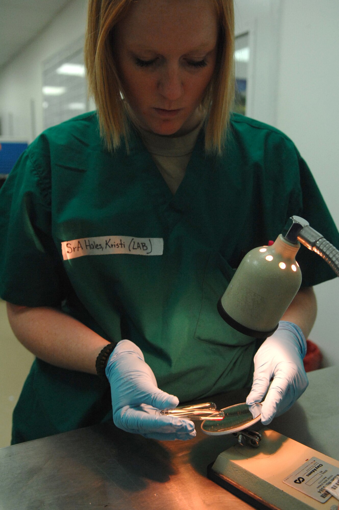 BALAD AIR BASE, Iraq -- Senior Airman Kristi Hales, 332nd Expeditionary Medical Support Squadron lab technician, examines small vials of blood after they have been put through a spinning process to determine the blood type here, June 5. Before giving blood products to trauma patients a blood type must be established to ensure the wrong type is not given. Airman Hales is deployed from Lackland Air Force Base, Texas. (U.S. Air Force photo/ Senior Airman Julianne Showalter)