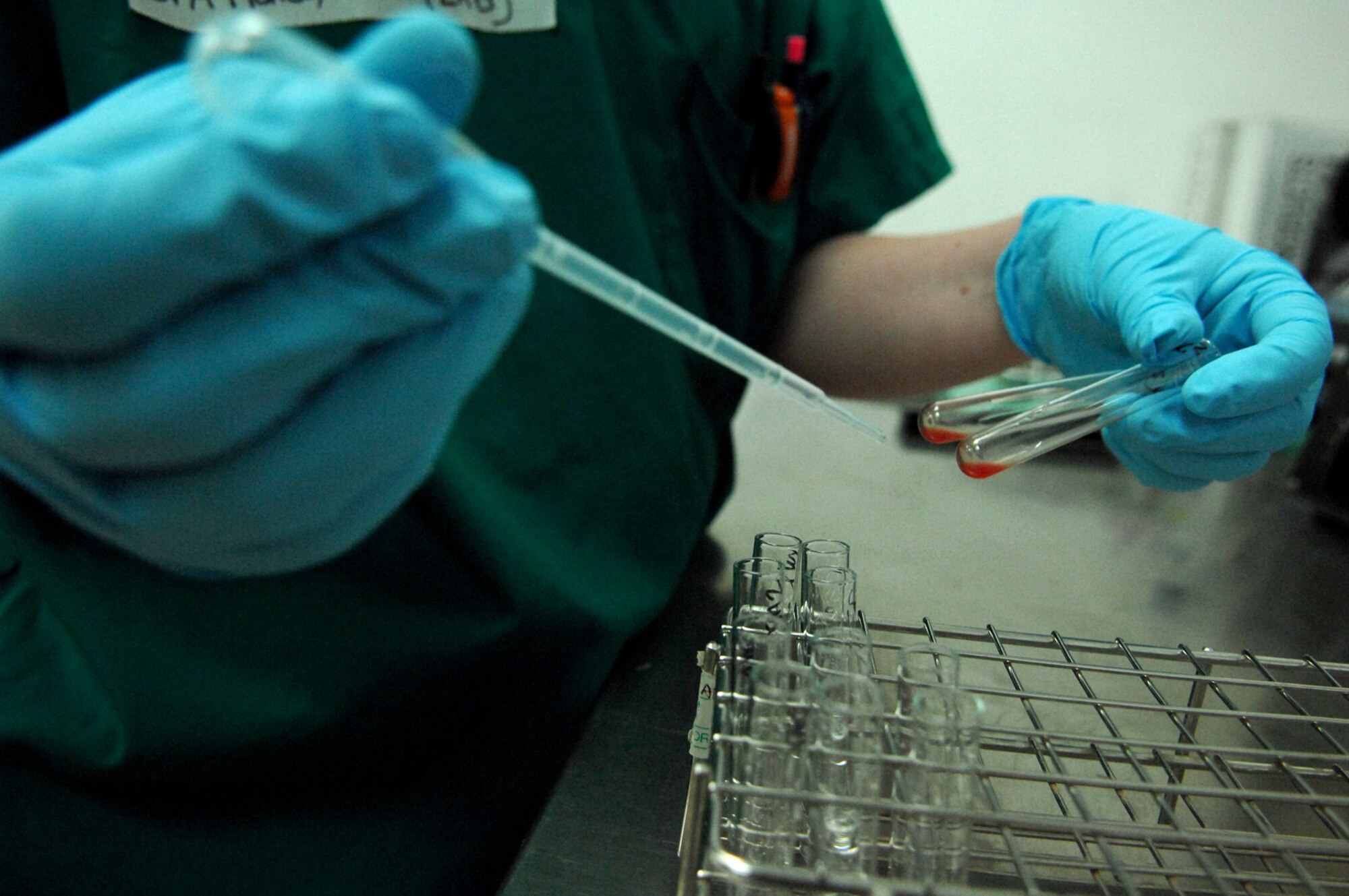 BALAD AIR BASE, Iraq -- Senior Airman Kristi Hales, 332nd Expeditionary Medical Support Squadron lab technician, puts saline into small vials of blood to determine the blood type of a trauma patient at the Air Force Theater Hospital here, June 5. Blood typing enables the technicians to give the correct type of blood product to the patient. Airman Hales is deployed from Lackland Air Force Base, Texas. (U.S. Air Force photo/ Senior Airman Julianne Showalter) 