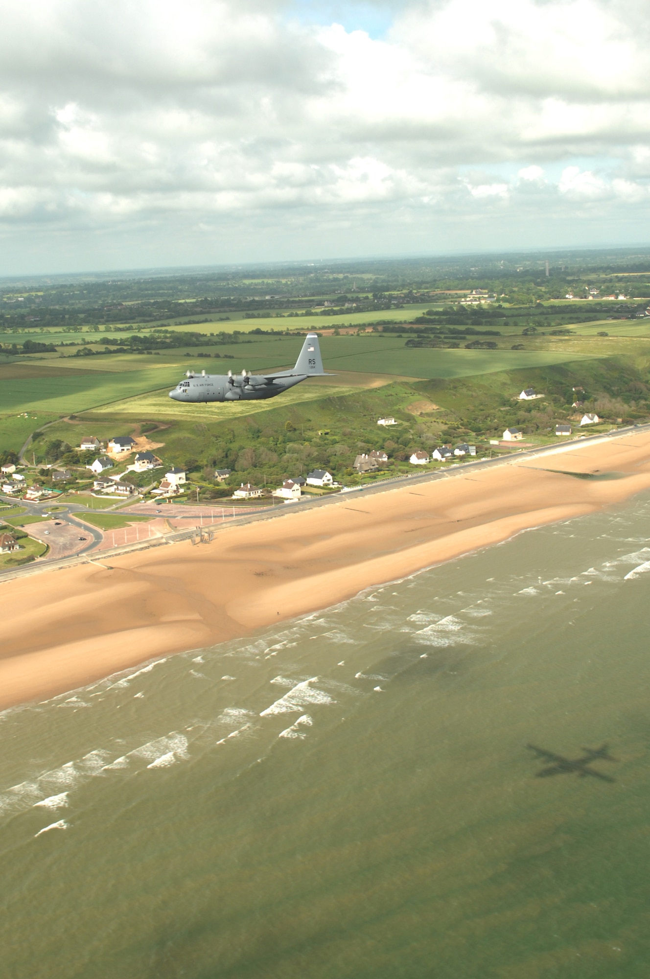 Airmen from the 37th Airlift Squadron fly past the beaches of Normandy, France in a C-130 Hercules June 6. The fly-by was done to commemorate those who were lost 64 years ago during the Normandy invasion, D-day. Photo by Airman 1st Class Amber Bressler*
