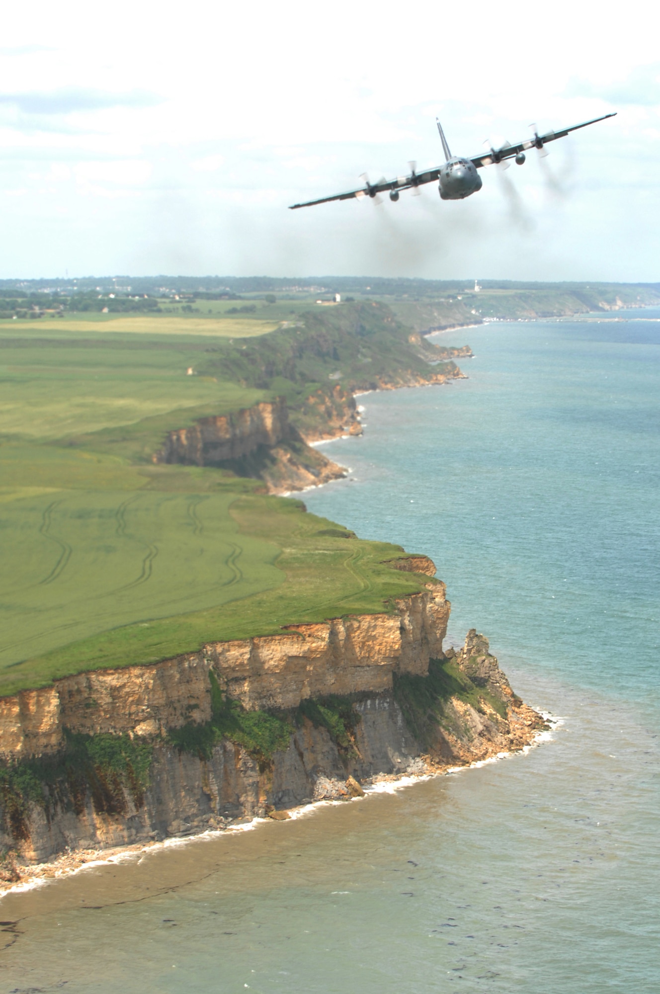 Airmen from the 37th Airlift Squadron fly past the beaches of Normandy, France in a C-130 Hercules June 6. The fly-by was done to commemorate those who were lost 64 years ago during the Normandy invasion, D-day. Photo by Airman 1st Class Amber Bressler*