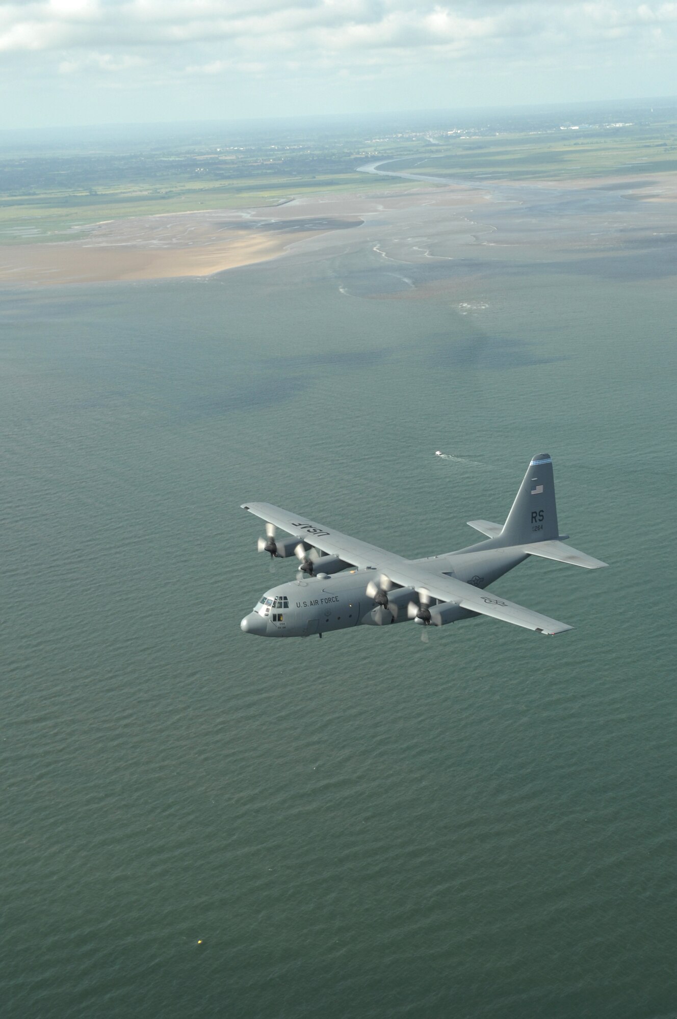 Airmen from the 37th Airlift Squadron fly past the beaches of Normandy, France in a C-130 Hercules June 6.  The fly-by was done to commemorate those who were lost 64 years ago during the Normandy invasion, D-day. Photo by Airman 1st Class Amber Bressler*