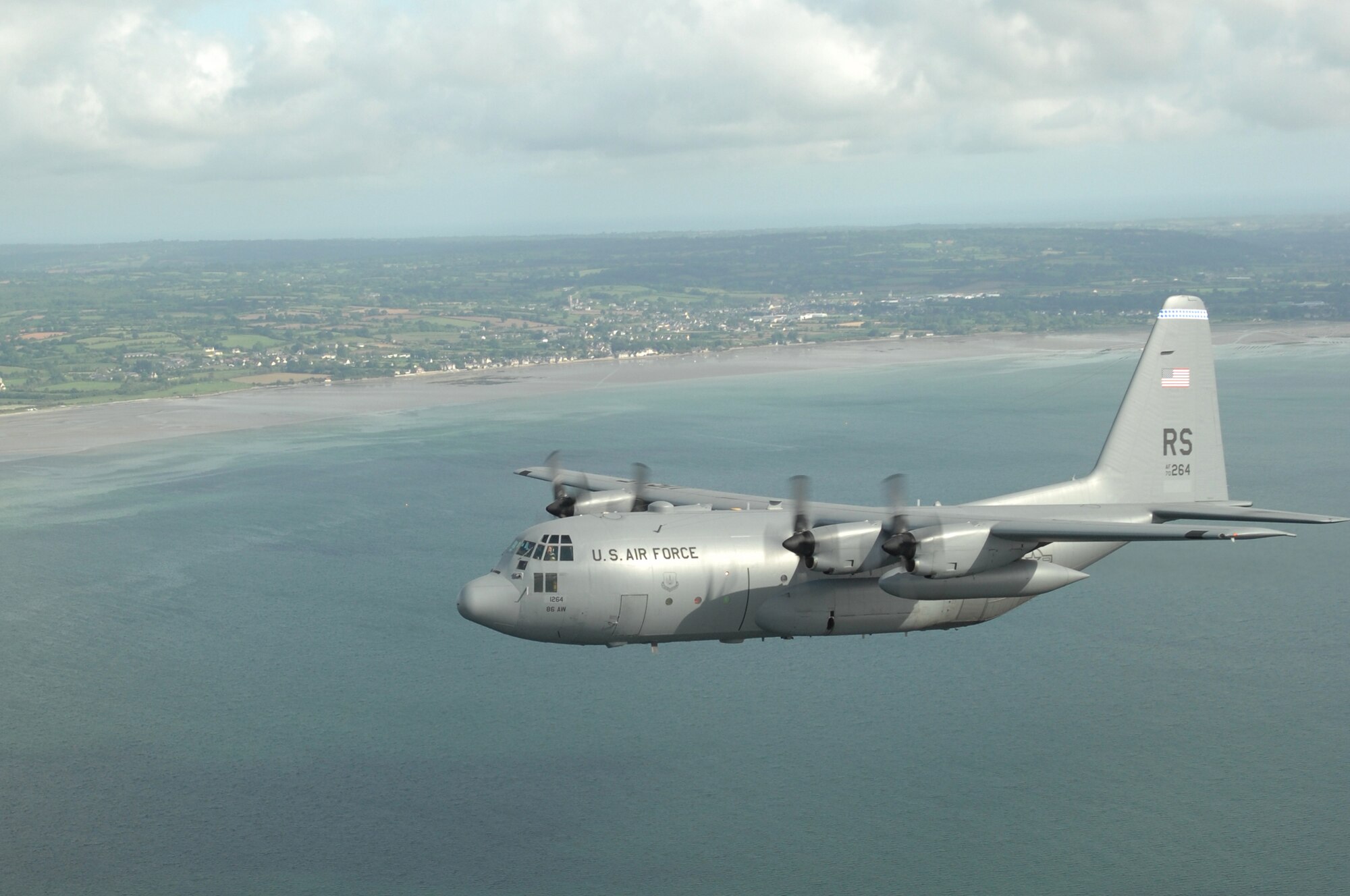 Airmen from the 37th Airlift Squadron fly past the beaches of Normandy, France in a C-130 Hercules June 6.  The fly-bys were done to commemorate those who were lost 64 years ago during the Normandy invasion, D-day. Photo by Airman 1st Class Amber Bressler*