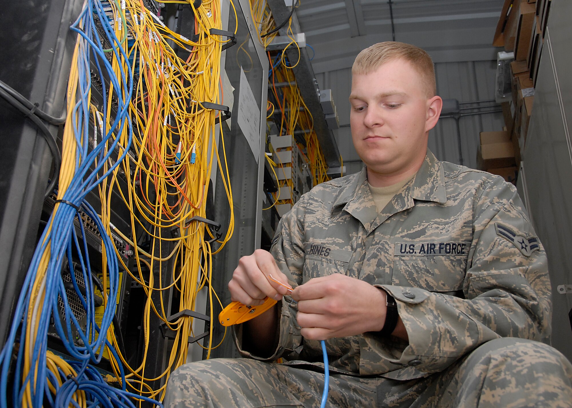 SOUTHWEST ASIA – Airman 1st Class John Hines, 386th Expeditionary Communications Squadron cable antenna systems shop, creates a patch cord for a network switch used to bring a computer on-line to the local area network. Airman Hines is one of 17 Airmen from the 386th ECS, 386th Expeditionary Civil Engineer and Force Support Squadrons who recently teamed-up to improve the Oasis morale center. The center provides Airmen a 24-hour operation to reach out and touch their family and friends, and to ensure their personal affairs stay in order. (U.S. Air Force photo/Tech. Sgt. Michael O’Connor)