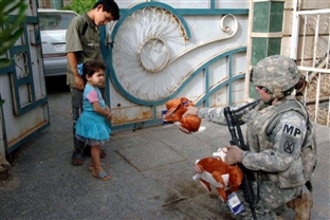 U.S. Army Sgt. Terra Salisbury hands a stuffed bunny rabbit to an Iraqi girl outside Eastern Baghdad, Iraq, June 3, 2008. Salisbury is assigned to the 10th Mountain Division's Brigade Special Troops Battalion, 4th Brigade Combat Team, Military Police Platoon, which is conducting a census of homes just outside Forward Operating Base Loyalty, Iraq. 