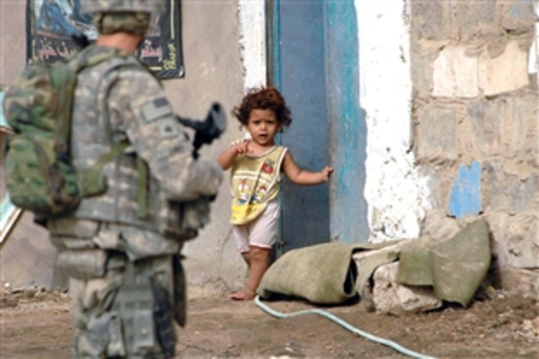 A U.S. Army soldier is greeted by a young Iraqi girl outside her home as soldiers inspect a cleaning project in her small village in Thawra 1 neighborhood of the Sadr City district of Baghdad, May 31, 2008. The soldiers are assigned to 1st Brigade, 6th Infantry. 
