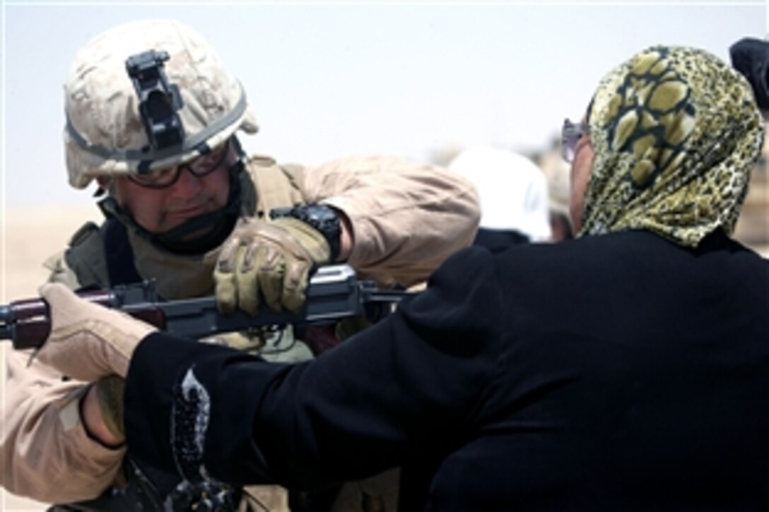 U.S. Marine Chief Warrant Officer Charles Major shows an Iraqi woman how to handle an AK-S as part of Sisters of Ferris training in Ferris, Iraq, June 4, 2008. Major is assigned to the 6th Marine Regiment's 3rd Battalion. The Sisters of Ferris is an organization of Iraqi women who will help Iraqi police search and handle female detainees. 