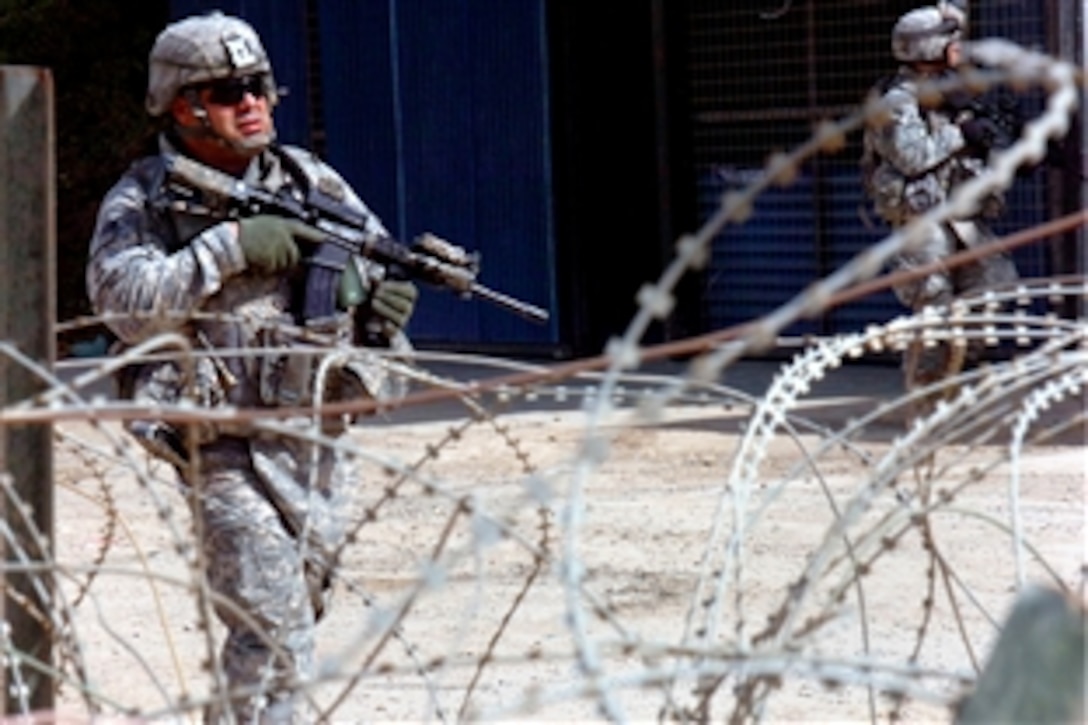 U.S. Army Staff Sgt. Jerry Anderson walks through the streets of Muthana in east Baghdad with Iraqi army soldiers during a combined search mission, June 5, 2008. Anderson is assigned to the 10th Mountain Division's Company D, 2nd Battalion, 30th Infantry Regiment.