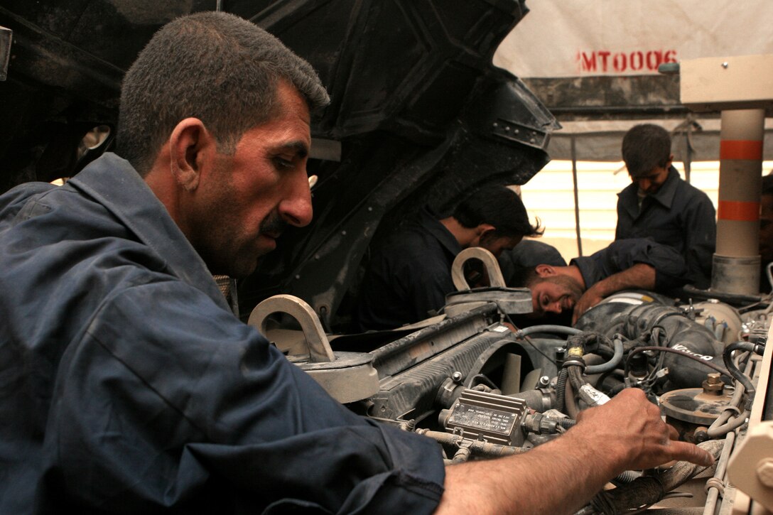 An Iraqi Policeman inspects a hose fitting during a humvee maintenance course hosted by Maintenance Company, Combat Logistics Battalion 1, 1st Marine Logistics Group aboard Camp Fallujah, Iraq. The course taught the IPâ??s the basic mechanic skills necessary to maintain their humvees.::r::::n::