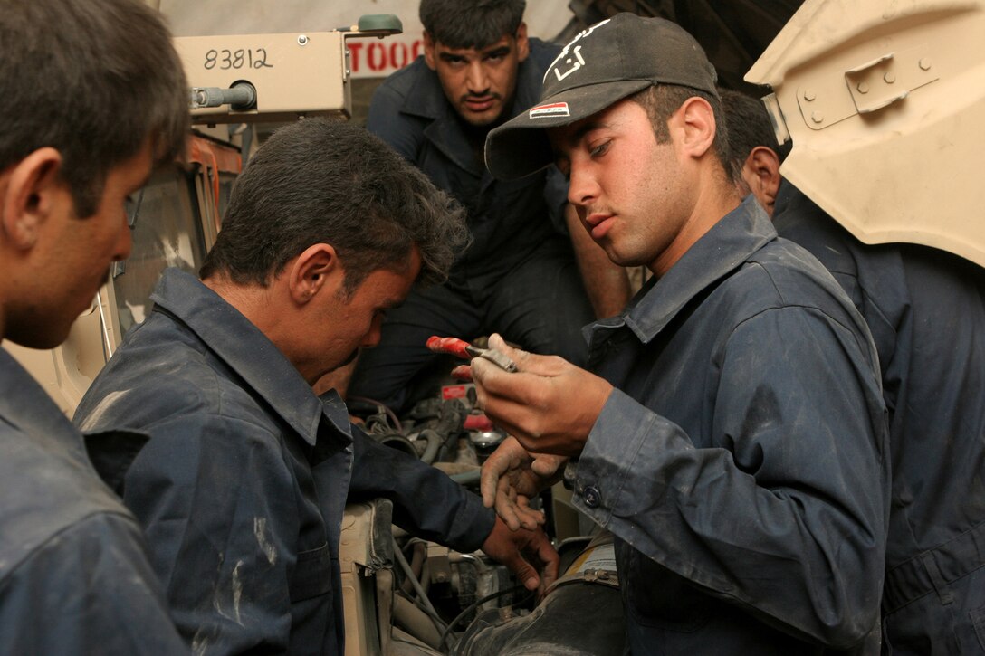 Iraqi policemen from the Fallujah, Iraq area put the finishing touches under the hood of a humvee during the humvee maintenance course hosted by Maintenance Company, Combat Logistics Battalion 1, 1st Marine Logistics Group. The course taught the IPs basic mechanic skills regarding the brake systems, fuel and exhaust system, tire repair and basic electrical troubleshooting.::r::::n::