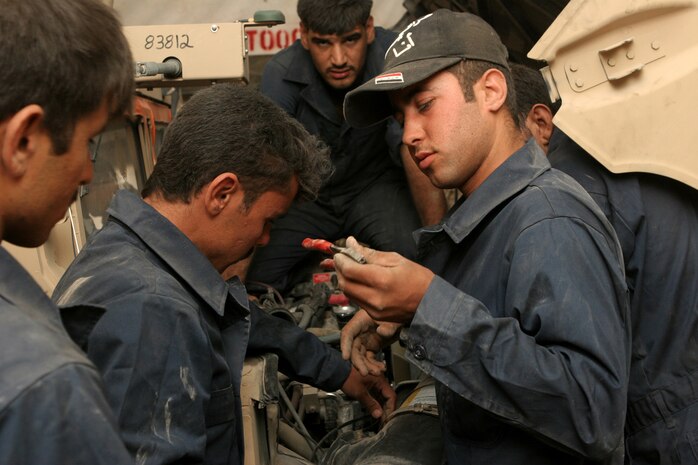 Iraqi policemen from the Fallujah, Iraq area put the finishing touches under the hood of a humvee during the humvee maintenance course hosted by Maintenance Company, Combat Logistics Battalion 1, 1st Marine Logistics Group. The course taught the IPs basic mechanic skills regarding the brake systems, fuel and exhaust system, tire repair and basic electrical troubleshooting.::r::::n::