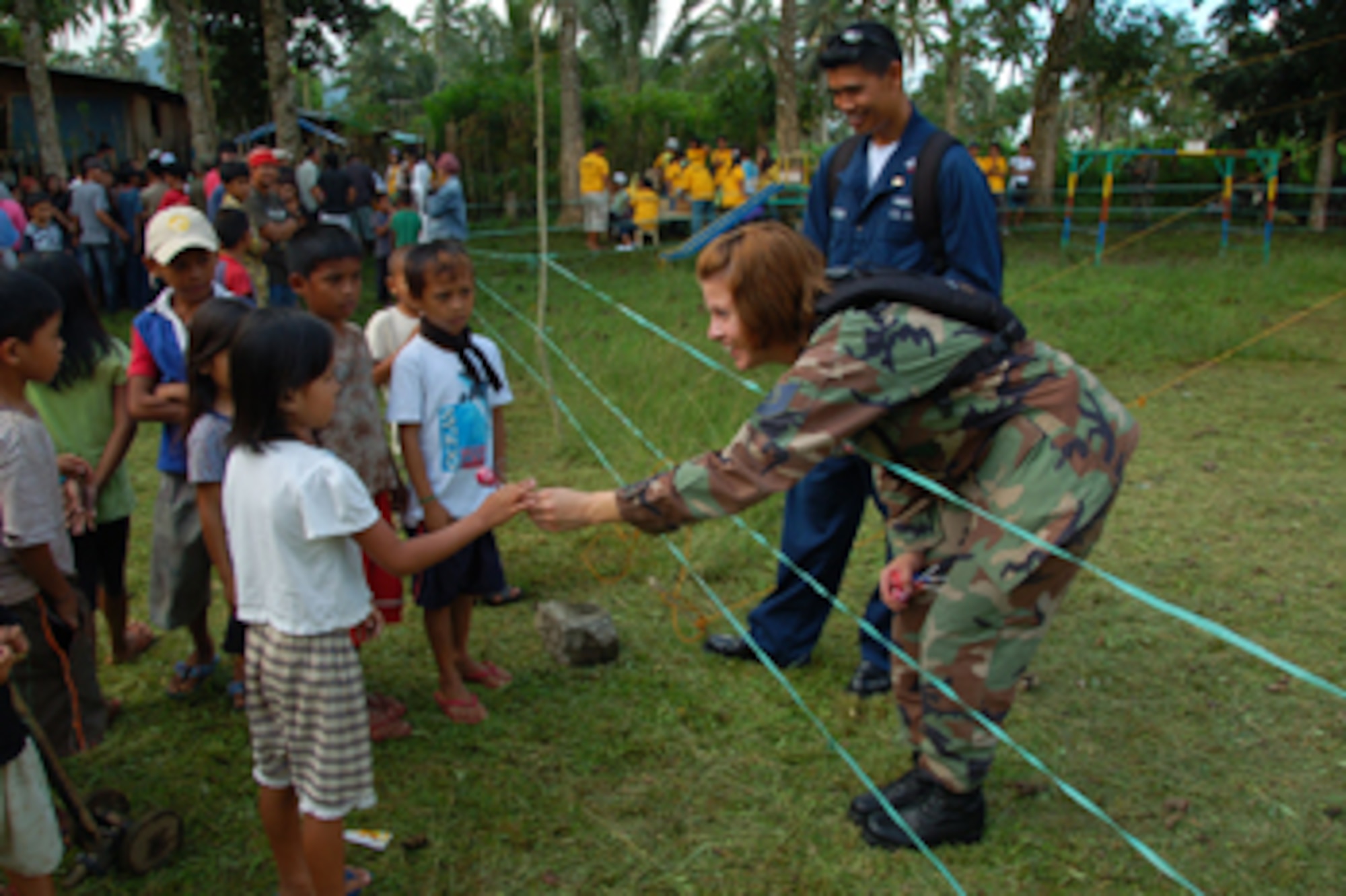 MAGUINDANAO, Philippines (May 31, 2008) - U.S. Air Force Tech. Sgt. Angela Custer, Cannon Air Force Base, N.M.,and Hospital Corpsman 2nd Class (SW) Francis Asuncion give candies to Filipino children.  The medical team that was sent to the district of Matanog, Maguindanao, provided free medical and dental care to people in need.  The U.S. Navy and Air Force are deployed aboard USNS Mercy for Pacific Partnership 2008 to provide care needed to assist the people of the region. (U.S. Navy photo by Mass Communication Specialist 2nd Class (SW) Mark Logico) (RELEASED) 