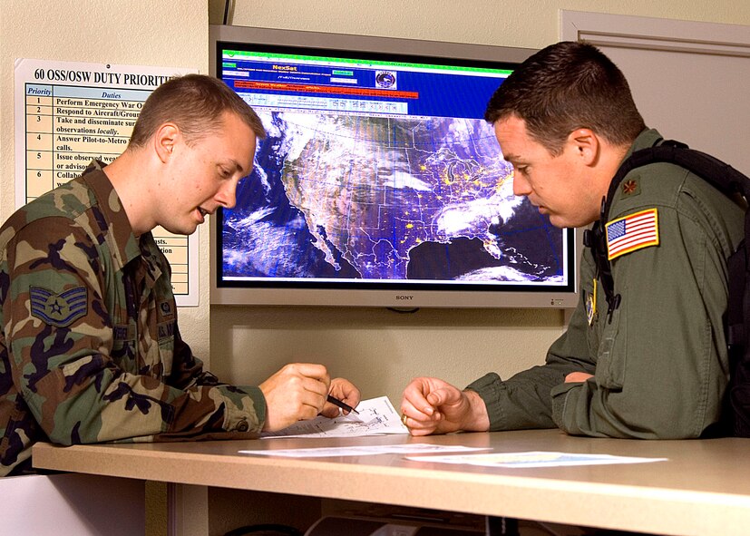 LocalTime:0718hr  ZuluTime:1418hr(Right to left)  Staff Sergeant Jason Weber, a Combat Weather Forecaster and a member of the 60th Operations Support Squadron, discusses weather conditions with Major Jeremy Geaslin, an Aircraft Commander with the 21st Airlift Squadron.  Air Crews have access to weather information 24 hours a day, 7 days a week at Travis Air Force Base, California.  USAF photo by Civ/ Nan Wylie