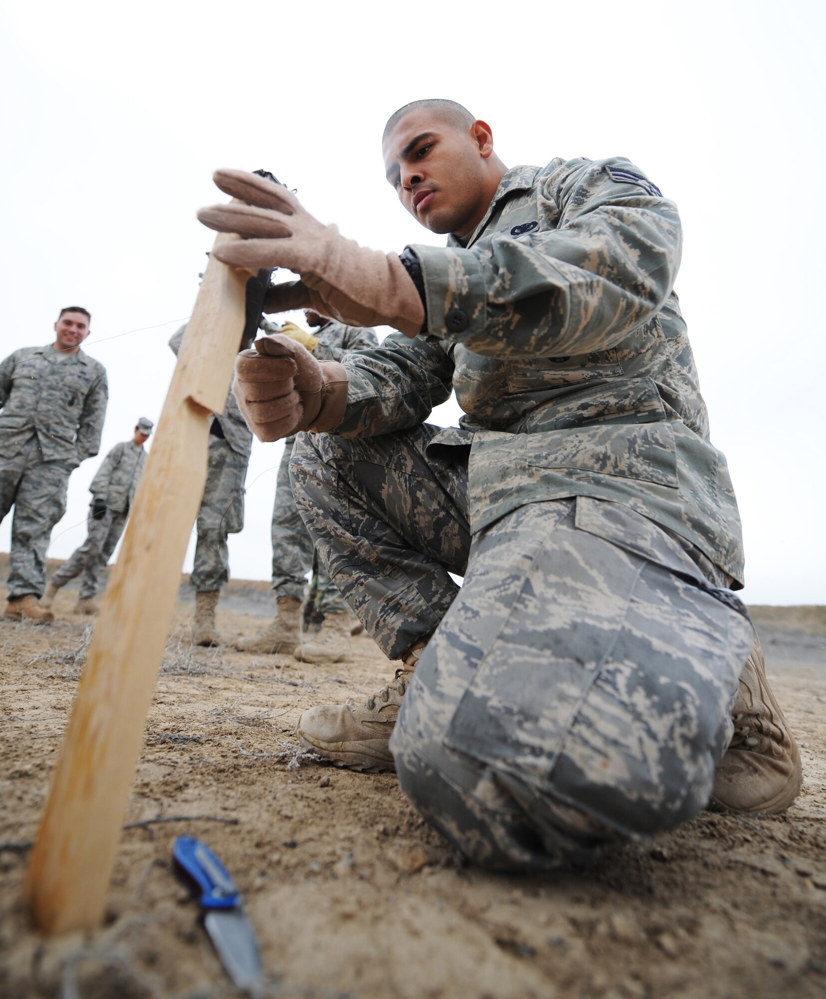 MOUNTAIN HOME AIR FORCE BASE, Idaho - Senior Airman Jesus Duran, 366th Security Forces Squadron patrolman, attaches wire to a trip flare during a training exercise June 4. Trip flares are used as an early warning system to alert SFS members of an incoming threat. The 366th SFS gives its members hands-on training in scenarios they may run into while in a deployed environment. (U.S. Air Force photo/ Airman 1st Class Ryan Crane)