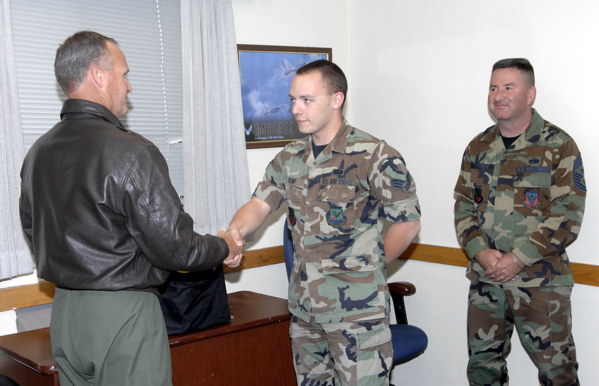 MOUNTAIN HOME AIR FORCE BASE, Idaho - Col. James Browne, 366th Fighter Wing commander, presents Senior Airman Lonnie Kemp, 366th Security Forces Squadron, with a wing coin after being named the Airman Against Drunk Driving’s Hero of the Quarter June 6 at the 366th SFS headquarters building. Airman Kemp had eight saves from January to March. (U.S. Air Force photo/ Staff Sgt. Brian Stives)