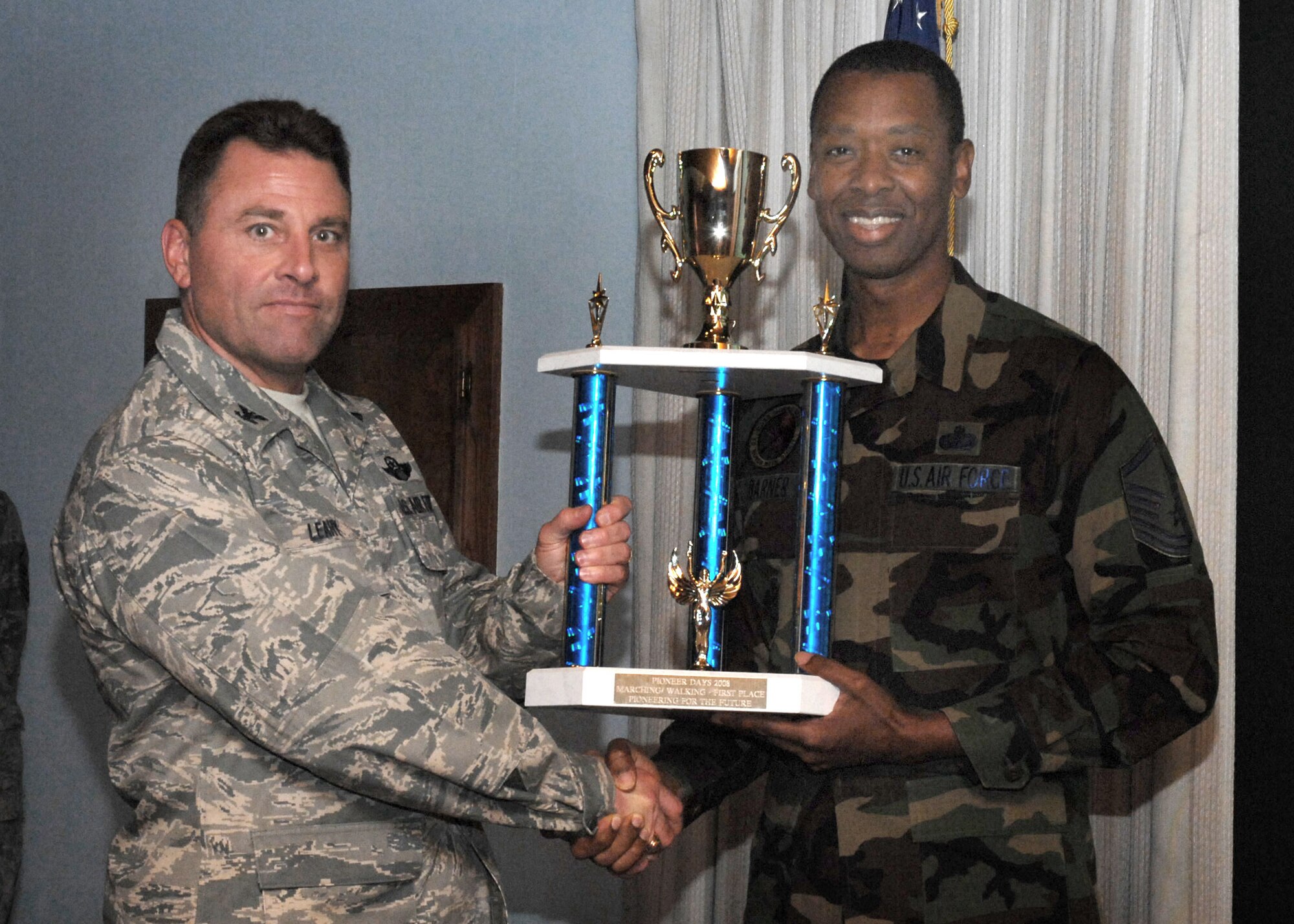 CANNON AIR FORCE BASE, N.M. -- Master Sgt. Rodney Barner, 27th Special Operations Services Squadron, receives the Marching/Walking first place trophy on behalf of the Base Honor Guard presented by Col. Timothy Leahy, 27th Special Operations Wing commander, June 10. The Base Honor Guard marched in the Pioneer Days 2008 Parade. (U.S. Air Force photo/Airman 1st Class Evelyn Chavez)