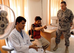 Capt. Matt Hayes looks on as Afghan National Army Capt. Sayed Zaman gives an eye exam to 18-year-old recruit Rahman Ullah June 9 at the Kabul Military Training Center. Captain Hayes is sharing his insight with a team of doctors at the Afghan National Army in-processing facility to help improve the process. He is assigned to the 437th Medical Group. (Photo by Guy Volb)