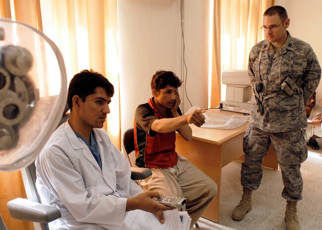 Capt. Matt Hayes looks on as Afghan National Army Capt. Sayed Zaman gives an eye exam to 18-year-old recruit Rahman Ullah June 9 at the Kabul Military Training Center. Captain Hayes is sharing his insight with a team of doctors at the Afghan National Army in-processing facility to help improve the process. He is assigned to the 437th Medical Group. (Photo by Guy Volb)