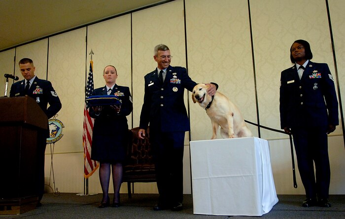 Col. Frank Jones pets Liz during her retirement ceremony on Charleston Air Force Base, S.C., June 10, 2008. Colonel Jones is the 437th Mission Support Group commander and Liz is a military working dog who has served in the 437th Security Forces Squadron for 10 years and has been on a multitude of temporary duty assignments to include Greece, Saudi Arabia and Iraq. She also went on seven different Secret Service and Department of State missions to protect President Bush and President Clinton. (U.S. Air Force photo/Senior Airman Nicholas Pilch)