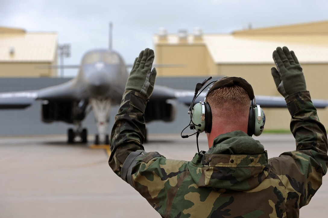 Staff Sgt. Dallas Osburn, 337th Test Evaluation Squadron B-1B dedicated crew chief from Dyess Air Force Base, Texas, marshals a B-1B Lancer equipped with a Sniper Advanced Targeting Pod on the flight line, June 5. Members of the 337 TES deployed to Ellsworth to complete operational testing, tactics development and train 28th Bomb Wing Airmen on the Sniper ATP. (U.S. Air Force photo/Senior Airman Marc I. Lane)
